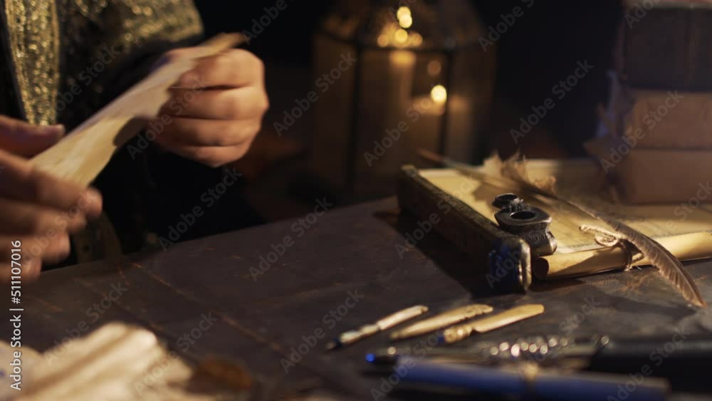 Arabic script in ancient times. The man who wrote the letter. Writing on parchment paper in the historical period. Pen made of ivory. Old era inkwell. Arabic script in ancient times. The man who wrote the letter. Writing on parchment paper in the historical period. Pen made of ivory. Old era inkwell.
