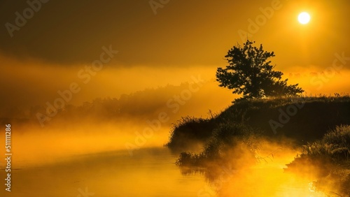 Fototapeta Naklejka Na Ścianę i Meble -  Wschód słońca nad rzeką Wartą. Słońce, mgła i rzeka o świcie