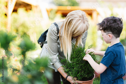 Grandmother and grandson examining potted plant