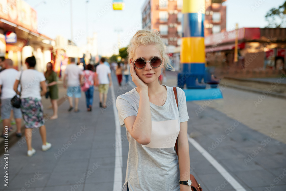 Beautiful charismatic young blonde woman, wear sunglasses, looking at camera.