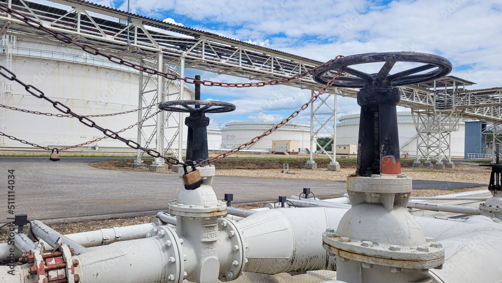 Valves locked by chain on the petrochemical tank farm with pipelines Valves locked by chain on the petrochemical tank farm with pipelines