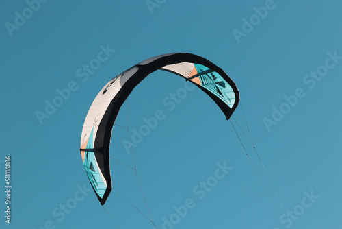 paraglider in the sky,kitesurf running on the waves, stormy blue sea, water drops in the sun