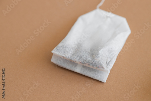 Tea bag with label on beige background, space for text