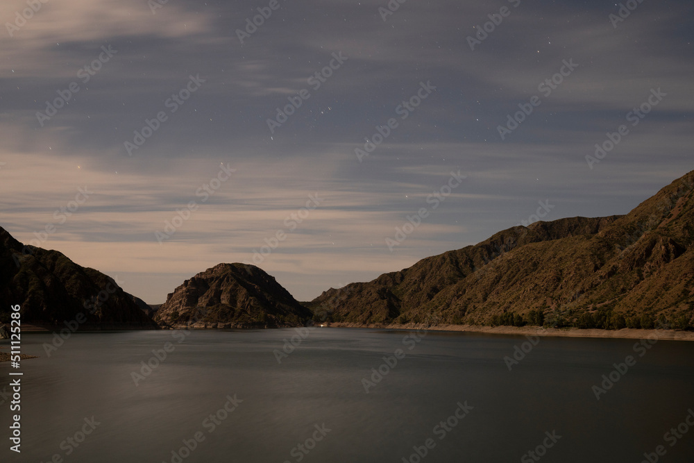 Night shot. View of the placid lake, stars and mountains. Beautiful blurred water effect and color generated by long exposure. Night shot. View of the placid lake, stars and mountains. Beautiful blurred water effect and color generated by long exposure.
