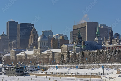 Old port of Montreal, with Bons secours cathedral and Bonsecours market, with skyscrapers of downtown Montreal, Quebec, Canada on a sunny winter day with clear blue sky 