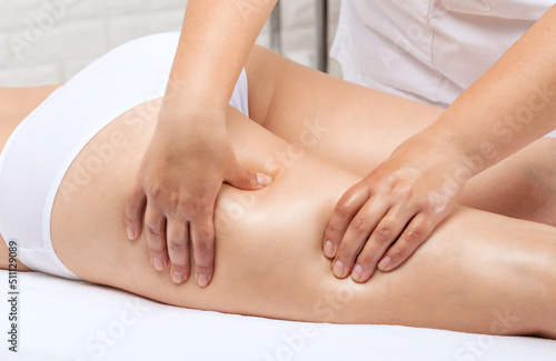 Masseur makes anti-cellulite massageon the legs, thighs, hips and buttocks in the spa. Overweight treatment, body sculpting.Cosmetology and massage concept. © Dimid