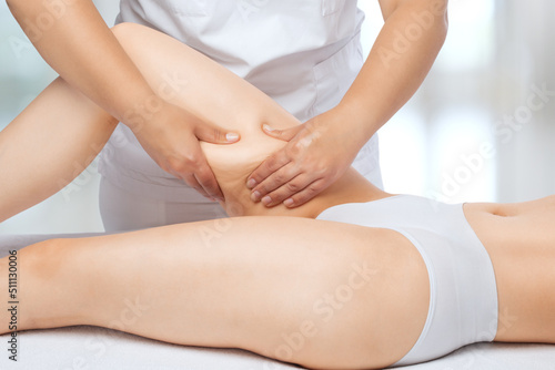 Masseur makes anti-cellulite massageon the legs, thighs, hips and buttocks in the spa. Overweight treatment, body sculpting.Cosmetology and massage concept.
