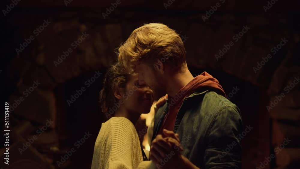 Happy lovers dance by cozy holiday fireplace closeup. Couple relax at home Happy lovers dance by cozy holiday fireplace closeup. Couple relax at home