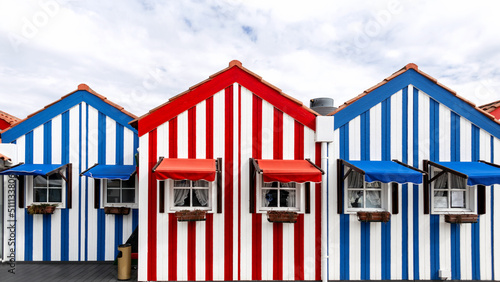 Beautiful vintage brightly colored creative houses with blue-white-red stripes on the beach in Costa Nova do Prado, Portugal. Fun and positive mood. Holidays in Europe
