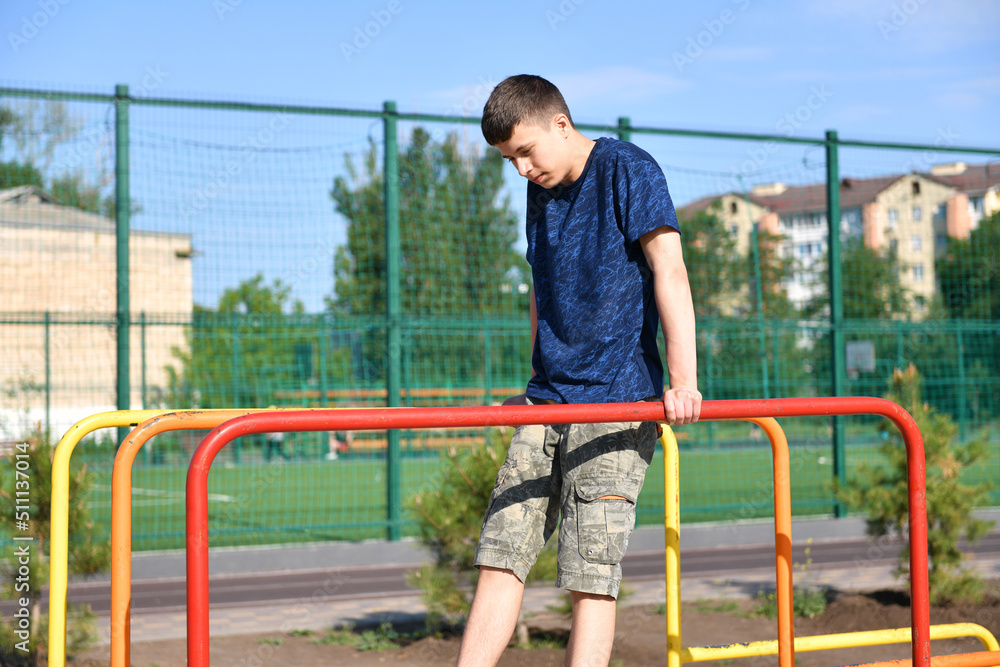 a teenage boy trains on a sports ground outdoors, he does physical exercises, a healthy lifestyle, a bright sunny day in summer a teenage boy trains on a sports ground outdoors, he does physical exercises, a healthy lifestyle, a bright sunny day in summer