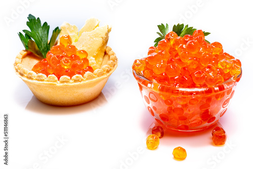Beautiful red caviar in small glass bowl with parsley on top. Caviar in tartlet with butter and parsley on white background.
