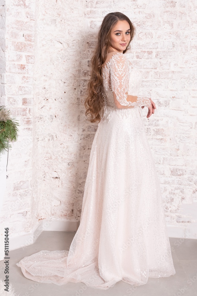 The bride in full growth, against the backdrop of a white brick wall. The bride in full growth, against the backdrop of a white brick wall.