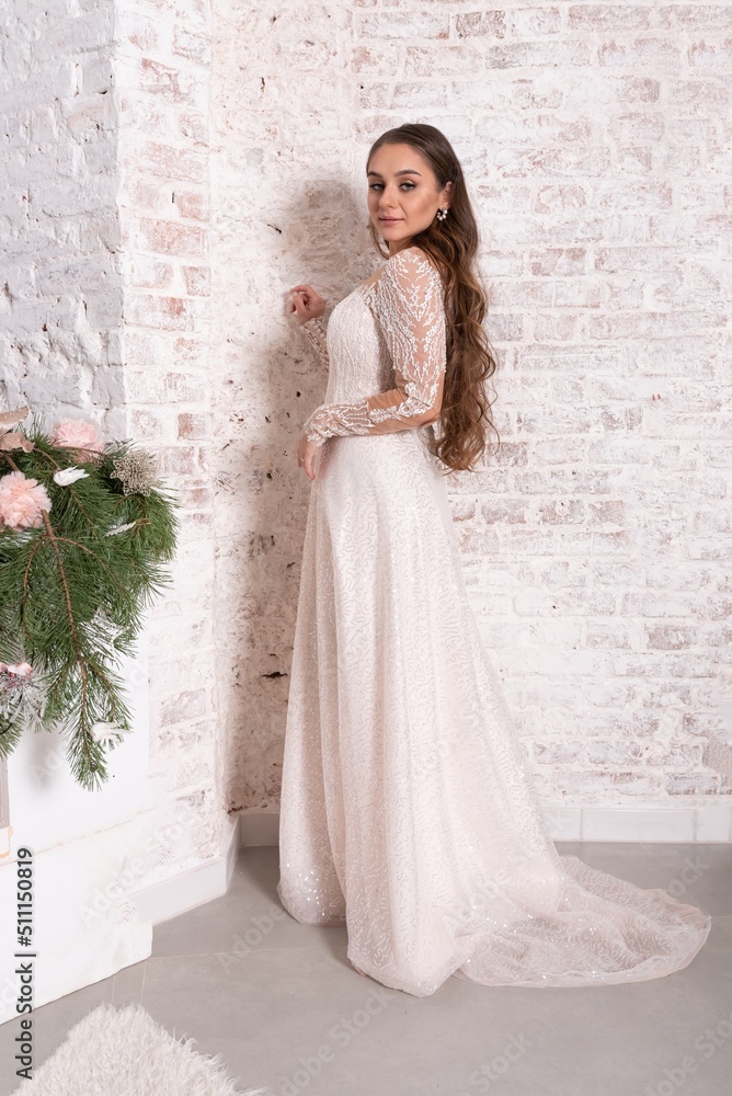 Bride in a white dress against a brick wall. Bride in a white dress against a brick wall.