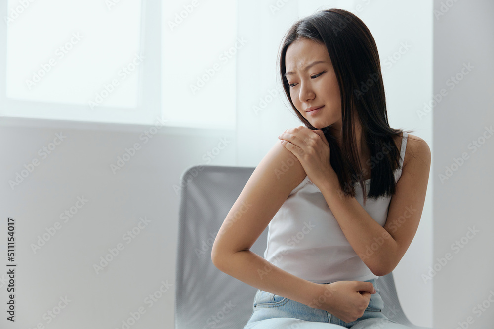 Suffering from neuralgia after sleeping in the wrong position tanned beautiful young Asian woman touching painful shoulder at home living room. Injuries Poor health Illness concept. Cool offer Banner Suffering from neuralgia after sleeping in the wrong position tanned beautiful young Asian woman touching painful shoulder at home living room. Injuries Poor health Illness concept. Cool offer Banner