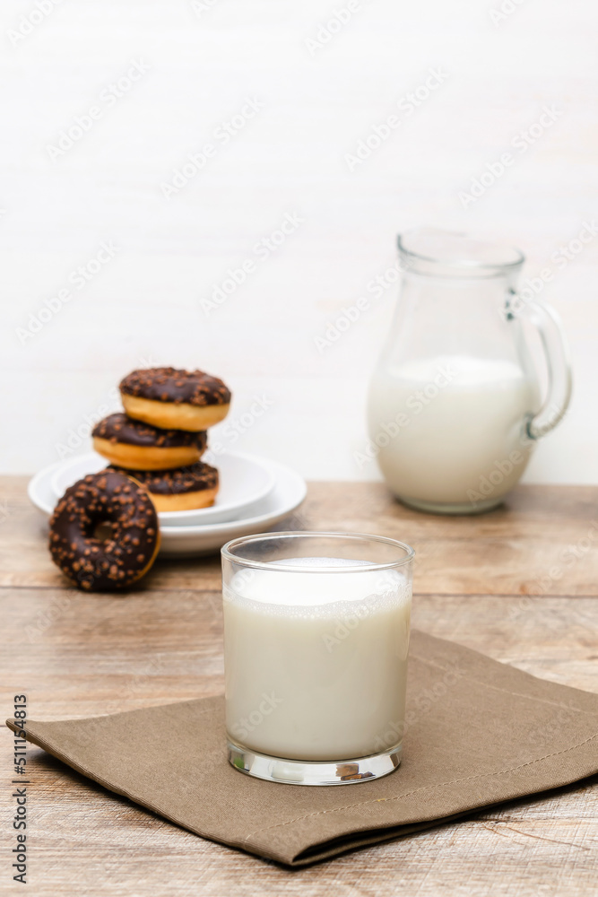 Mini donuts covered with chocolate glaze served with bottle, jug, glass of milk. Stack of tasty sweet sugar creamy or icing doughnuts dessert food on plate and napkin on kitchen. national donuts day Mini donuts covered with chocolate glaze served with bottle, jug, glass of milk. Stack of tasty sweet sugar creamy or icing doughnuts dessert food on plate and napkin on kitchen. national donuts day