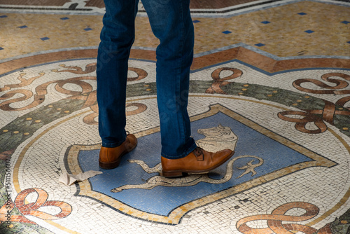 Bilde på lerret Man circles three times on the floor mosaic bull's testicles, it is believed it brings lucky to the person, on the Galleria Vittorio Emanuele, in Milan