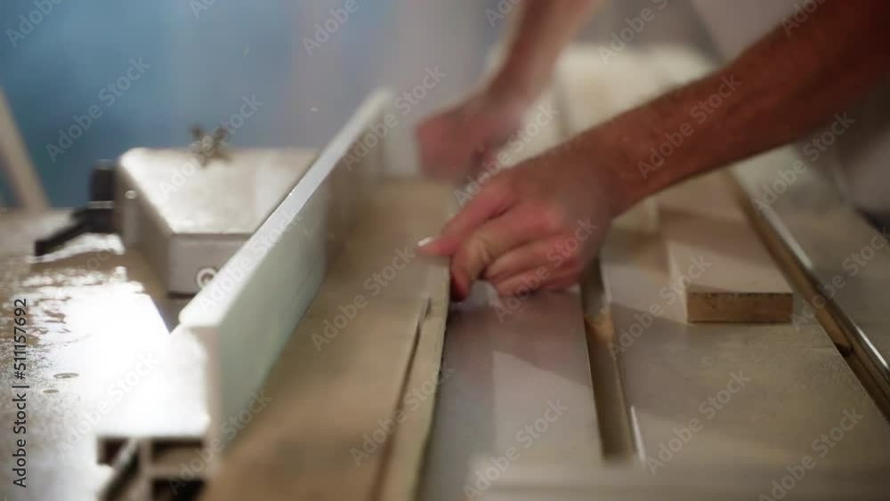 woodworking machine in workshop of carpenter, master is sawing wood board woodworking machine in workshop of carpenter, master is sawing wood board