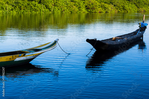 Canoes and boats docked on the Jaguaripe River photo