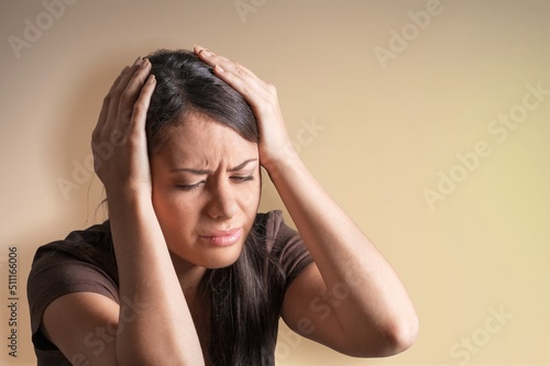 Young woman facing disaster, looking anxious in panic, holding hands on head frustrated, standing over background