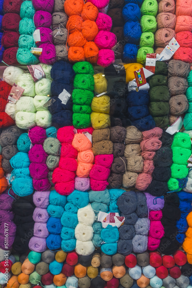 balls and skeins of colored yarn for knitting for sale. High quality photo