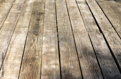 An old wooden pavement in a sunny day. Photo in perspective with selective focus