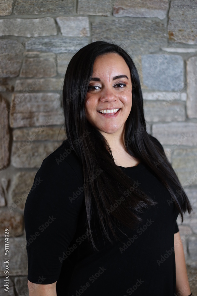 woman in black standing in front of stone wall