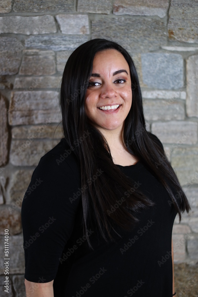 woman in black standing in front of stone wall