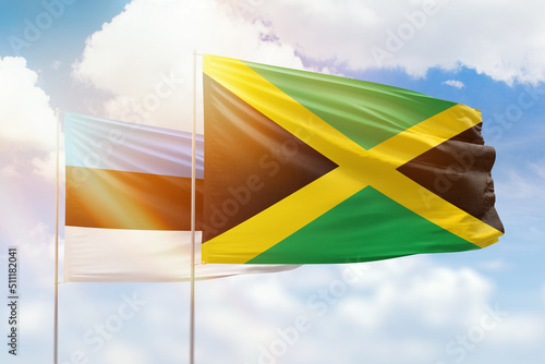 Sunny blue sky and flags of jamaica and estonia