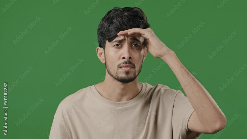 Puzzled nervous guy arab hispanic man posing on green background put head to forehead looking around into distance spy searching for someone peep out waiting make choice has bad eyesight myopia vision Puzzled nervous guy arab hispanic man posing on green background put head to forehead looking around into distance spy searching for someone peep out waiting make choice has bad eyesight myopia vision