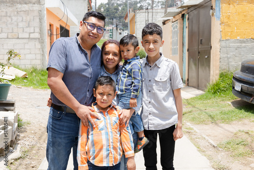 Fototapeta Latin family hugging outside their house in rural area - Happy Hispanic family i