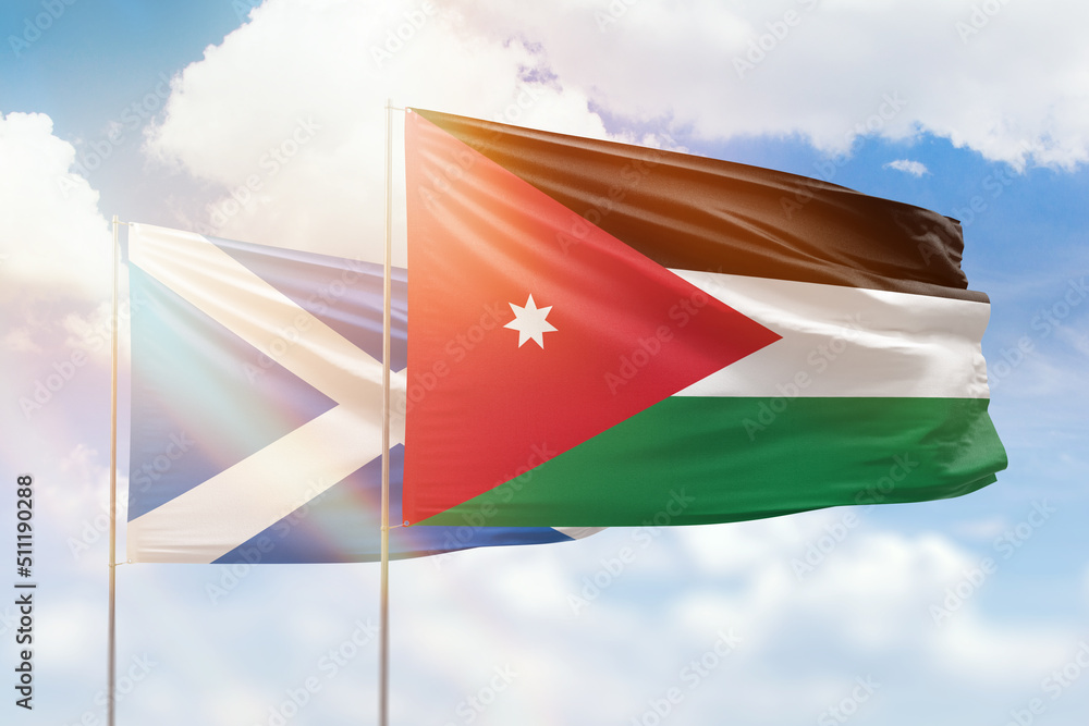 Sunny blue sky and flags of jordan and scotland Sunny blue sky and flags of jordan and scotland