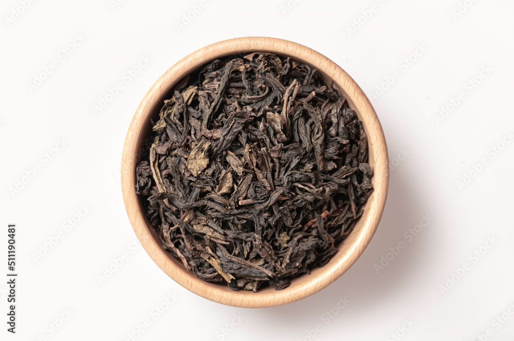 Top view Black tea leaves in wooden bowl on white Top view Black tea leaves in wooden bowl on white
