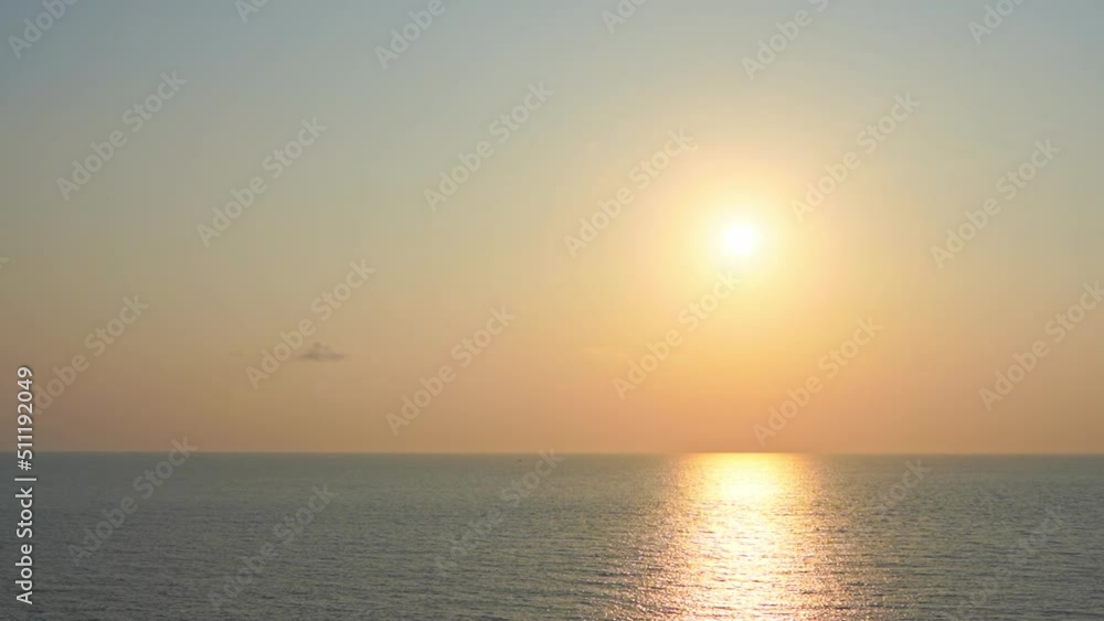 A golden sun hangs low in the sky over the endless ocean. Title space A golden sun hangs low in the sky over the endless ocean. Title space