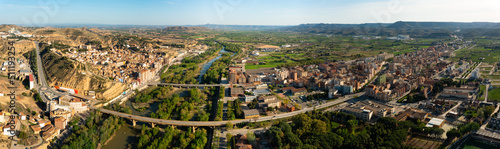 General panoramic aerial view of Spanish town of Fraga on banks of Cinca river and its surroundings on sunny day, province of Huesca, Aragon photo
