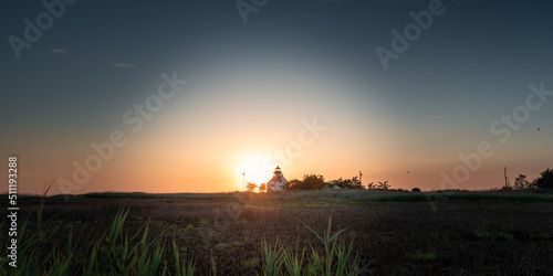 A distant shot of the sunset with the East Point Lighthouse. 