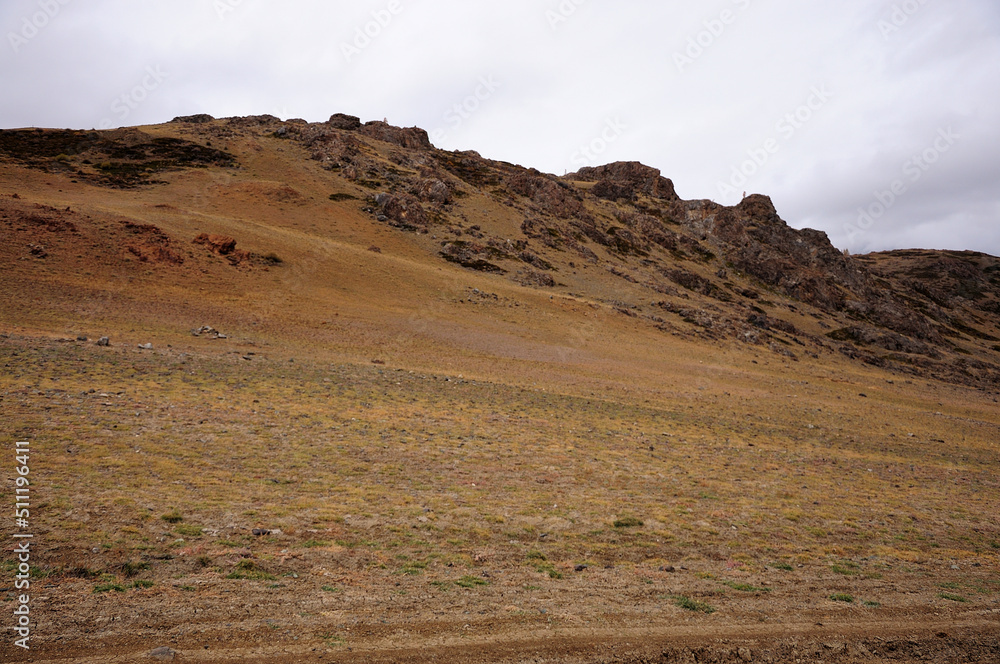 Rocky hill on the edge of arid and deserted autumn steppe.