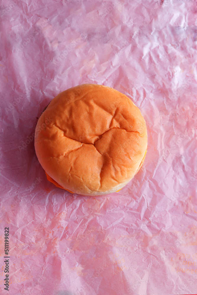 Cheese burger from a fast food restaurant shot from above on it’s paper wrapper Cheese burger from a fast food restaurant shot from above on it’s paper wrapper