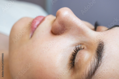 Close-up portrait of a young caucasian woman before eyelash lamination procedure. 