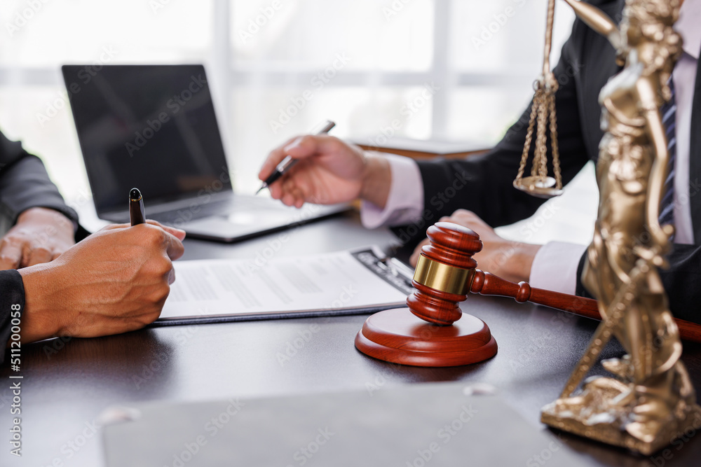 justice and law concept. male lawyer working in an office. Legal law, advice, and justice concept. The client is bringing the documents to clarify the law to the lawyer at the prosecutor's office. justice and law concept. male lawyer working in an office. Legal law, advice, and justice concept. The client is bringing the documents to clarify the law to the lawyer at the prosecutor's office.