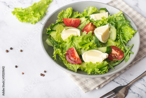 green salad with mozzarella on gray stone background