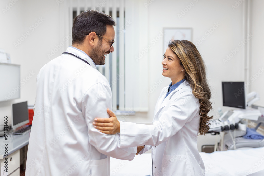 Two Professional confident doctor shaking hands while standing at the clinic .Teamwork of caucasian medical meeting and greeting by handshake at hospital .Medical team, health care concept. Two Professional confident doctor shaking hands while standing at the clinic .Teamwork of caucasian medical meeting and greeting by handshake at hospital .Medical team, health care concept.