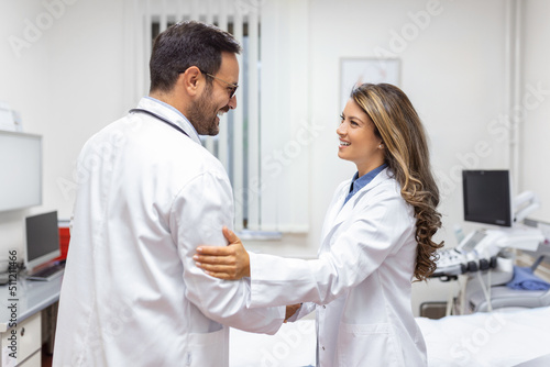 Two Professional confident doctor shaking hands while standing at the clinic .Teamwork of caucasian medical meeting and greeting by handshake at hospital .Medical team  health care concept.