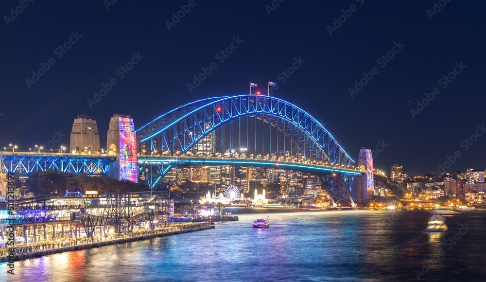 Colourful Light show at night on Sydney Harbour NSW Australia. The bridge illuminated with lasers and neon coloured lights 