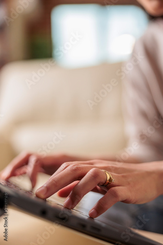 Close up of woman hands typing on laptop, asian female in background freelancer on computer working from home, remote job technology progress and web 3.0