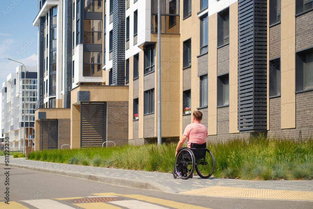 A man in a wheelchair walks through a city block, barrier-free environment