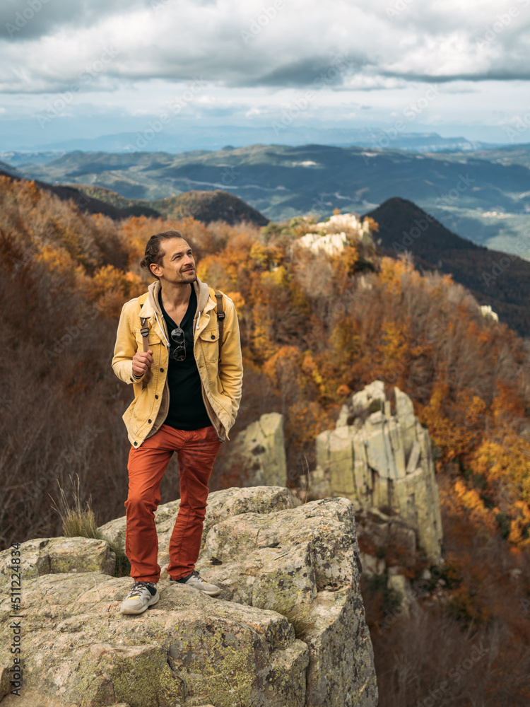 Traveler is standing on high rock, enjoying the view and looking up. Travel and hiking concept in autumn time. Traveler is standing on high rock, enjoying the view and looking up. Travel and hiking concept in autumn time.
