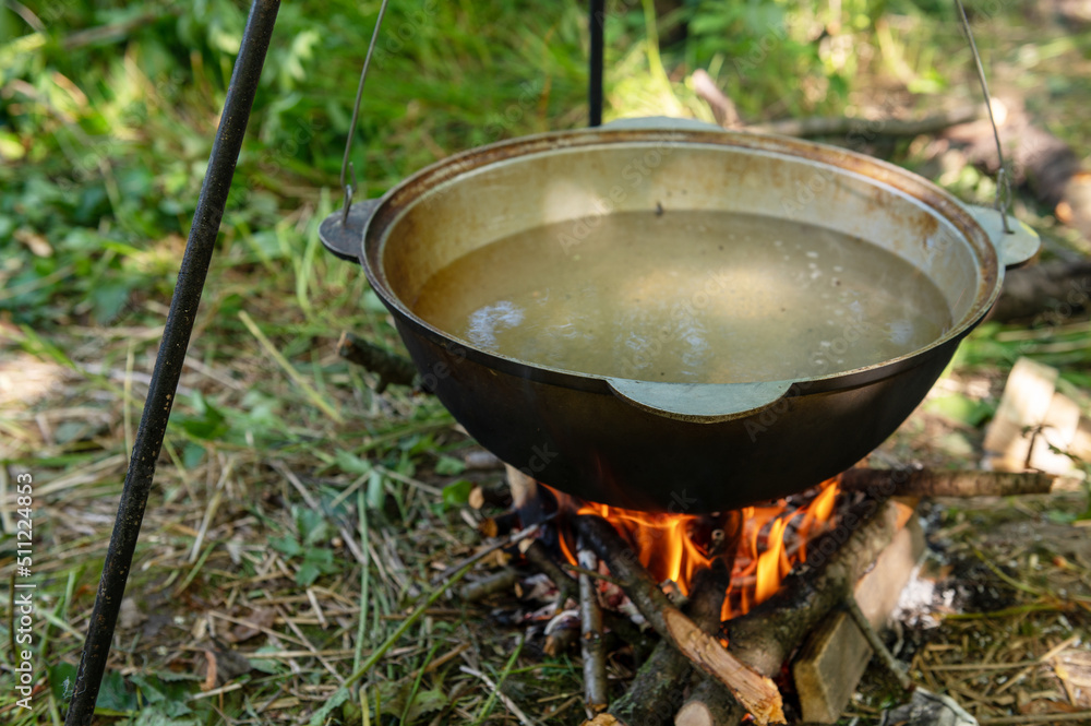 Cauldron on the fire. Cooking food on a campfire in a wild campsite on a summer day. Cauldron on the fire. Cooking food on a campfire in a wild campsite on a summer day.