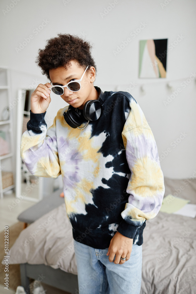 Vertical portrait of trendy Gen Z teenager wearing sunglasses and tie dye shirt Vertical portrait of trendy Gen Z teenager wearing sunglasses and tie dye shirt