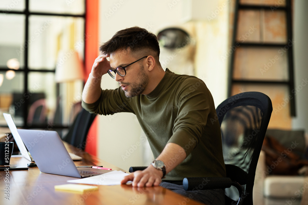 Tired businessman in office. Angry man working on laptop.. Tired businessman in office. Angry man working on laptop..