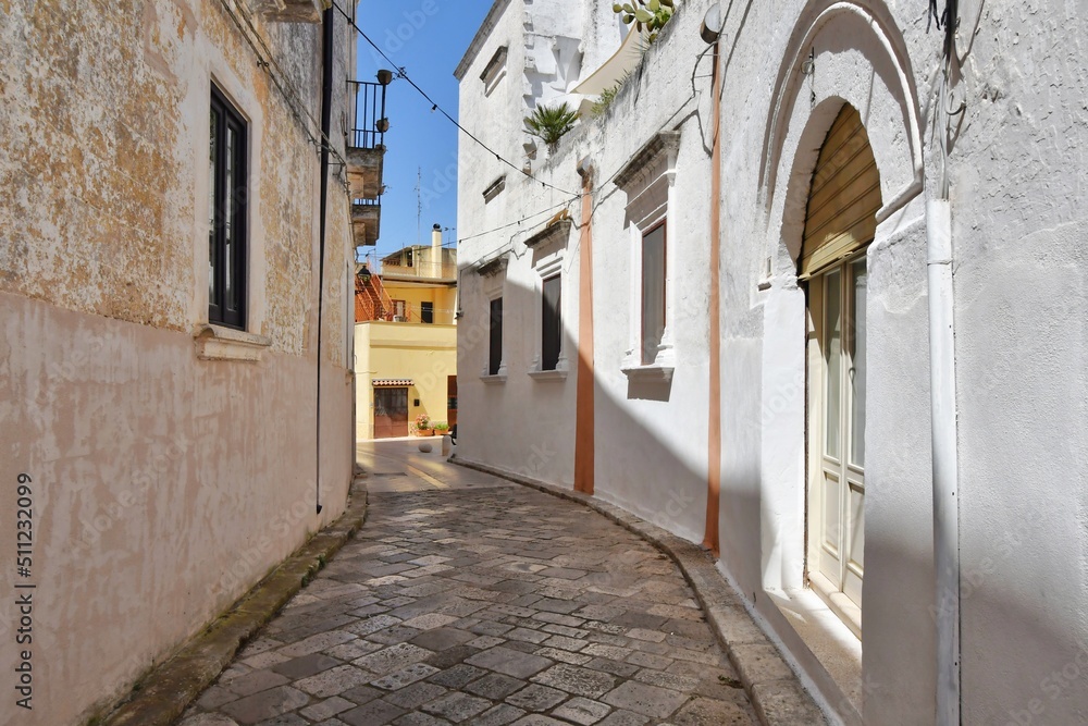 A narrow street between the old houses of Presicce, a picturesque village in the province of Lecce in Italy.